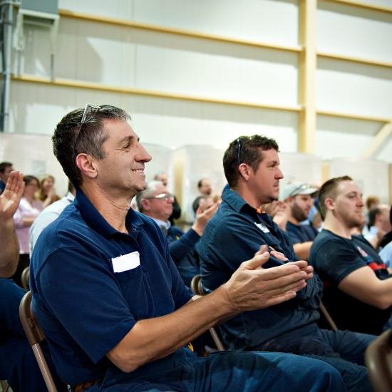 Employees applauding at company meeting