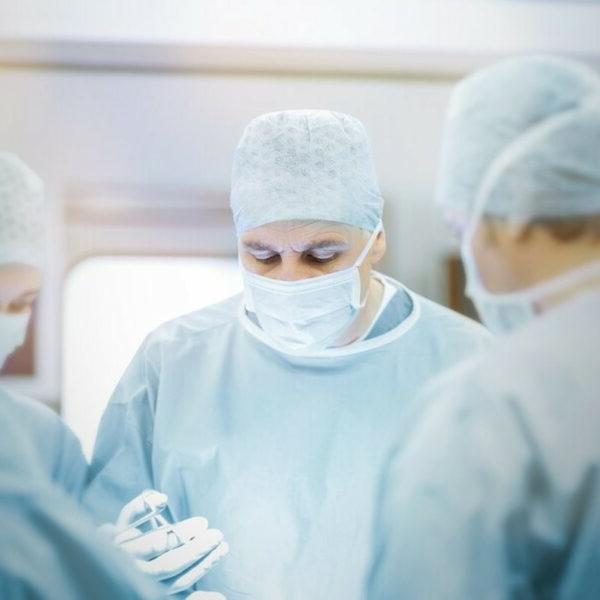 穿着长袍、戴着口罩的医生正在做手术