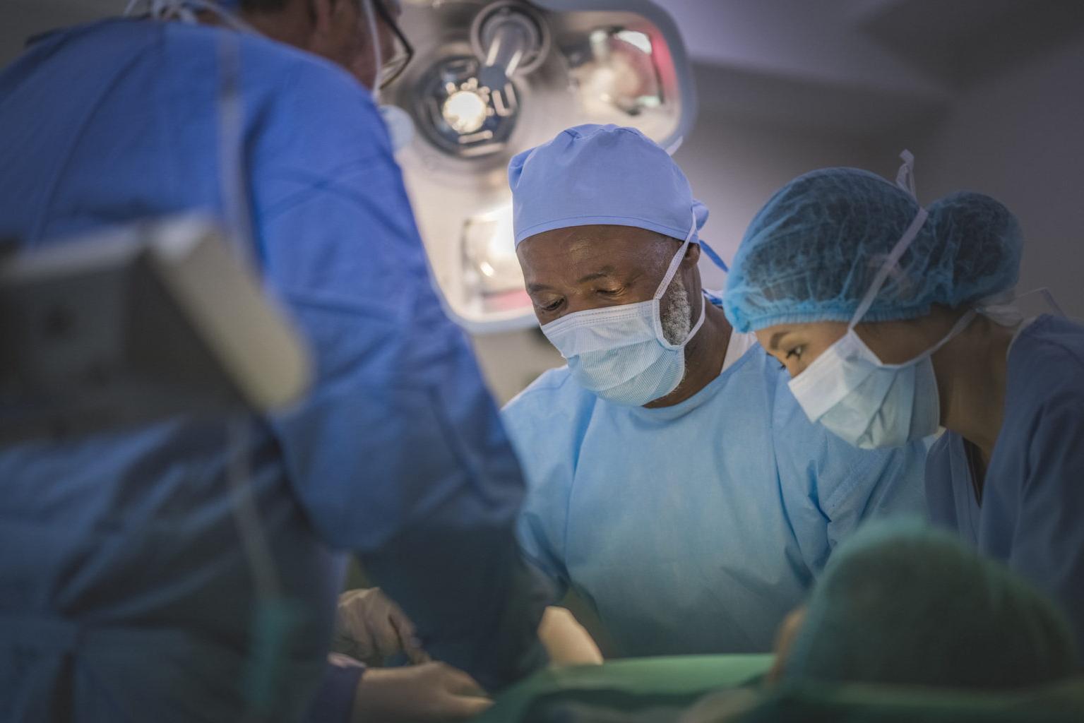 Multi-ethnic surgeons operating in emergency room